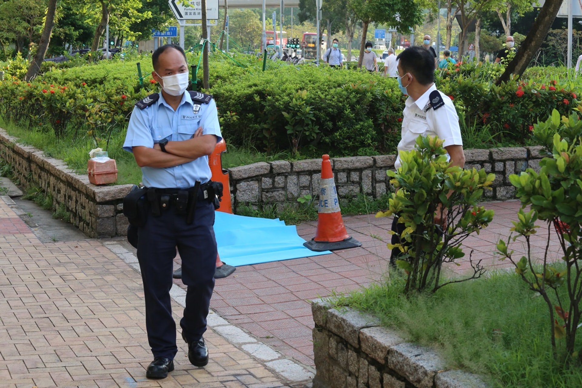 嬰屍被棄於垃圾桶旁，警員用藍布將屍體遮蓋調查。（劉定安攝）