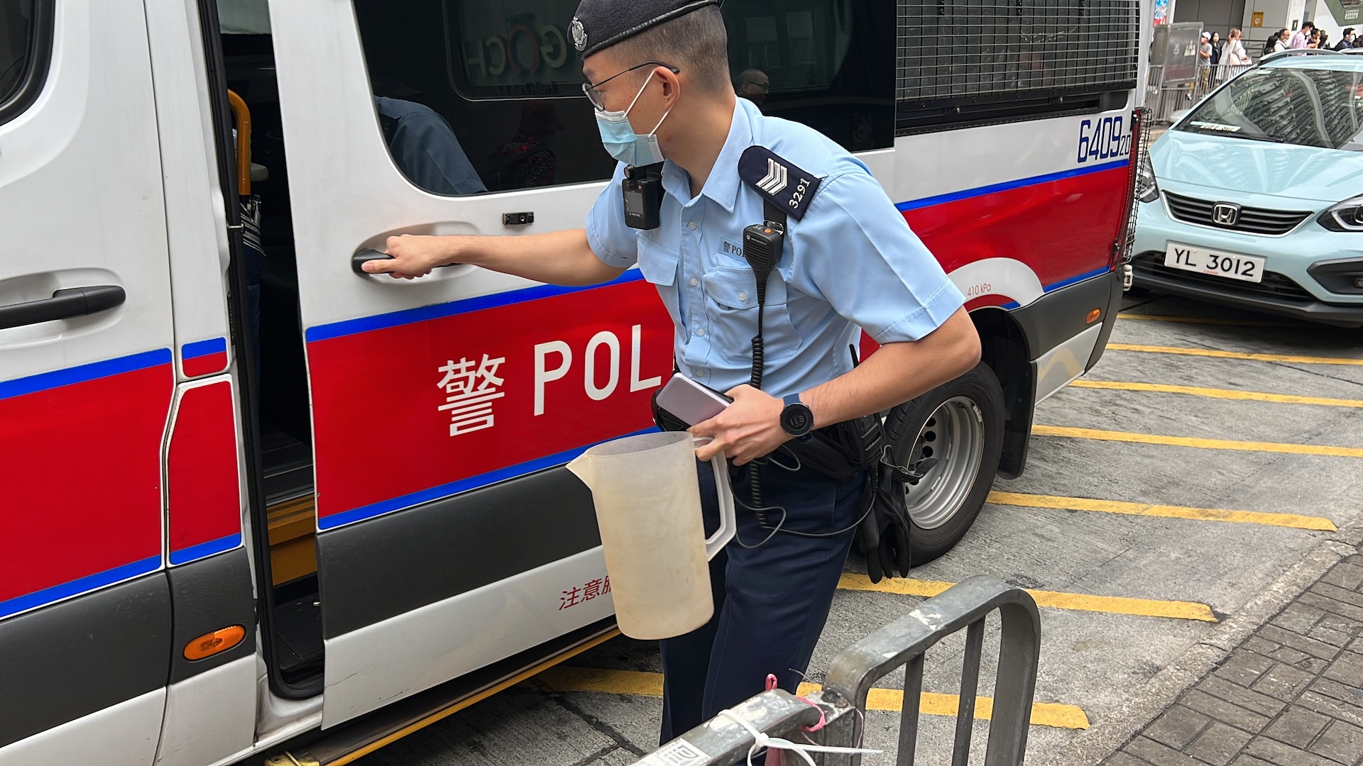 警員檢走膠水壼。（翁鈺輝攝）