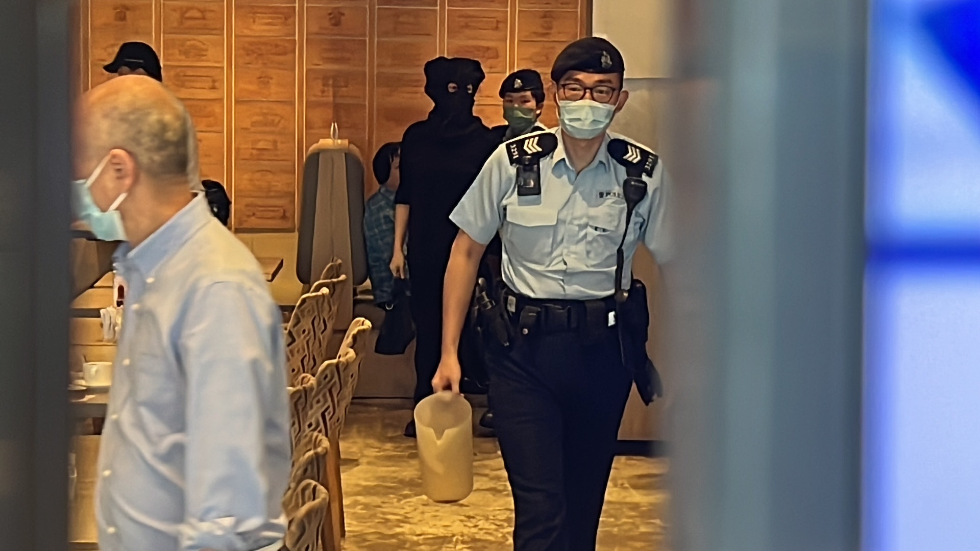 其中一名涉事女職員，被黑布蒙頭送院治理。（翁鈺輝攝）