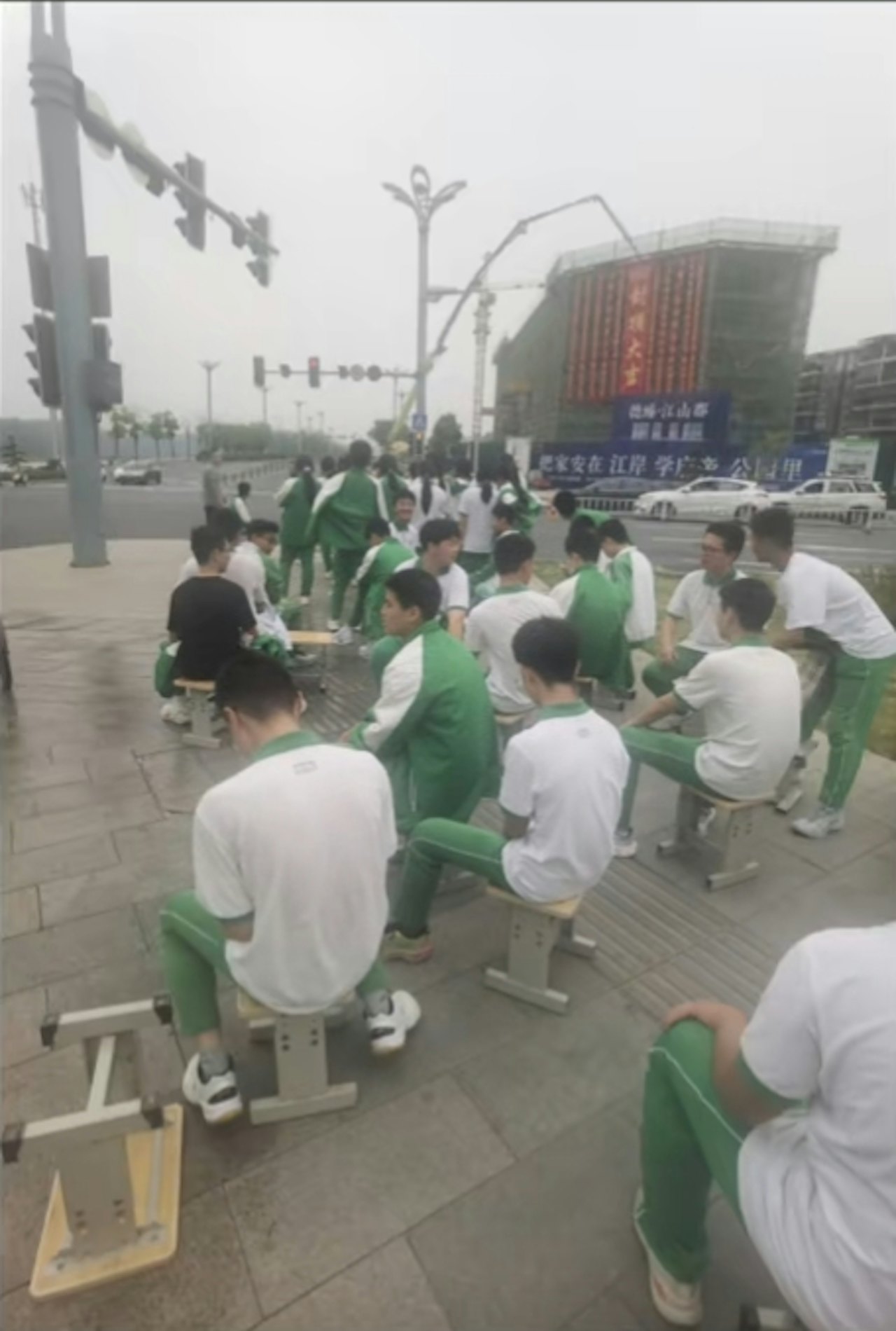 全班同學帶着板凳從學校出發,走路到約一公里外的醫院。(影片截圖) 全班同學帶着板凳從學校出發,走路到約一公里外的醫院。(影片截圖)