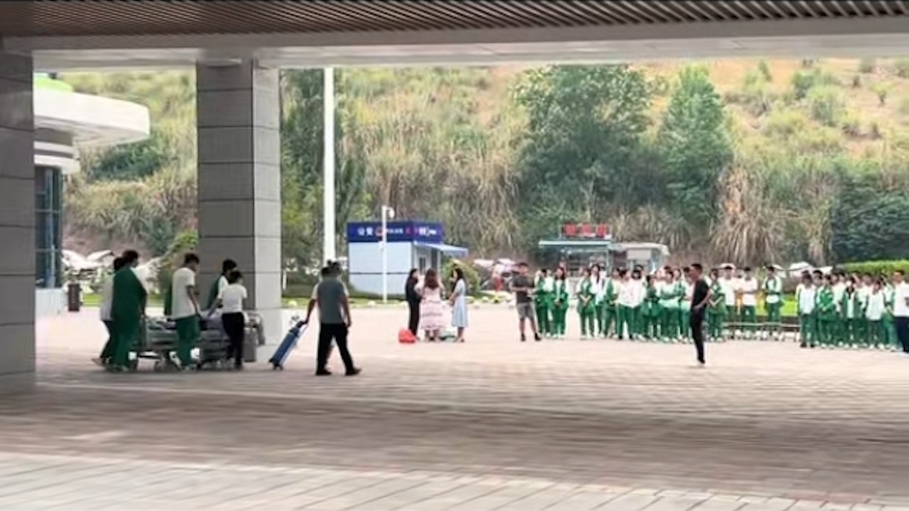 6名男同學將病床上推到醫院的廣場。(影片截圖) 6名男同學將病床上推到醫院的廣場。(影片截圖)
